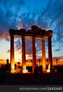 Lighted columns of the Temple of Apollo in Side at sunset. Silhouettes of people. Architectural heritage. A popular tourist destination. One of the main attractions of Turkey. Lighted columns of the Temple of Apollo in Side at sunset