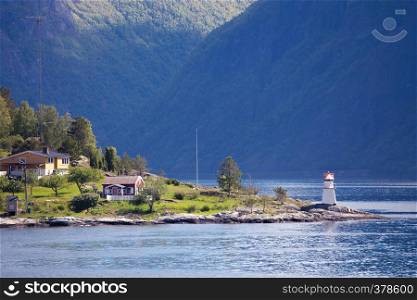 lighthouse and multicolored houses on a fjord shore