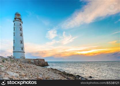 Lighthouse at sea coast. Lighthouse at sea coast with sunset sky