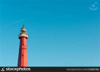 Lighthouse at sunset light over clear blue sky with copy space