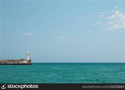 Lighthouse in the bay with sea and sky.