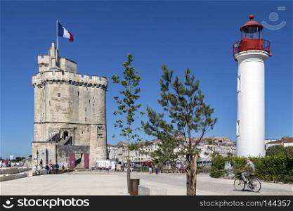 Lighthouse in the port of La Rochelle on the coast of the Poitou-Charentes region of France. The tower with the flag is the Tour de la Chaine which dates from the 11th century.