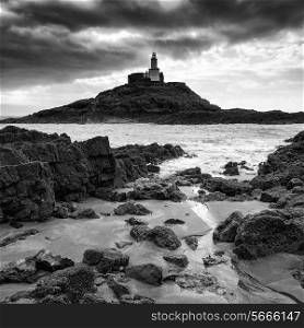 Lighthouse landscape with stormy sky over sea in black and white