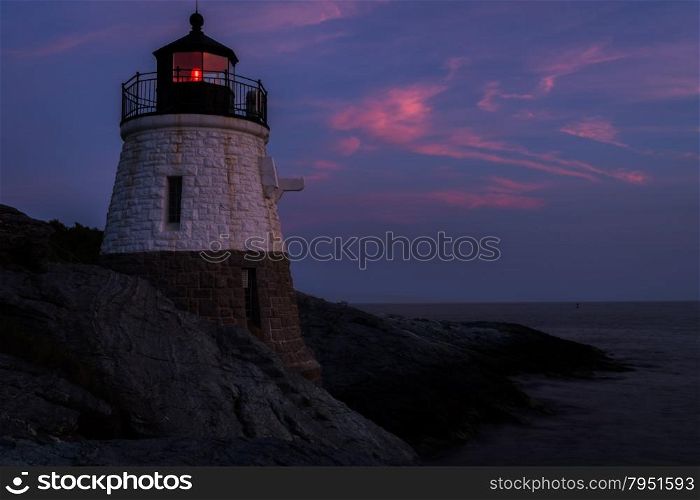 Lighthouse on a rocky shore at sunset.. Lighthouse on a rocky shore.
