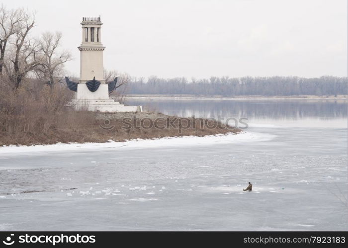 Lighthouse on Sarpinsk peninsula located at the entrance of the Volga-Don canal named after VI Lenin, in memory of the sailors, the defenders of the city in 1953, the city of Volgograd Krasnoarmeysky district, surrounded by ice fisherman sitting on it