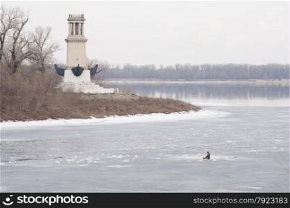Lighthouse on Sarpinsk peninsula located at the entrance of the Volga-Don canal named after VI Lenin, in memory of the sailors, the defenders of the city in 1953, the city of Volgograd Krasnoarmeysky district, surrounded by ice fisherman sitting on it
