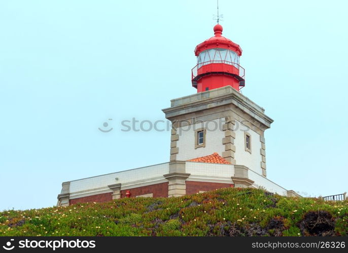 Lighthouse on summer blossoming Cape Roca (Cabo da Roca) with flowers, Portugal.