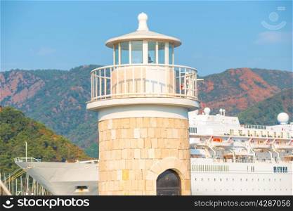 lighthouse on the background of mountains and cruise ship