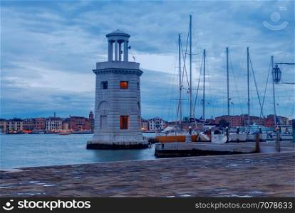 Lighthouse on the island of San Giorgio Maggiore at night.. Old lighthouse in the Venetian lagoon on the island of San Giorgio Maggiore on the sunset.