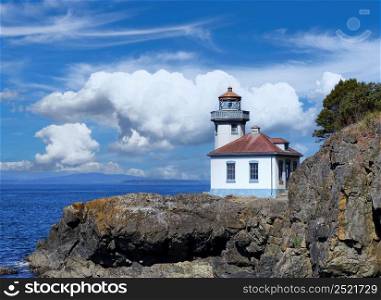 Lighthouse on the Puget Sound of Washington state during nice day with blue sky and clouds