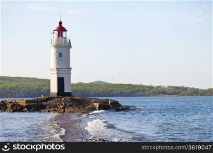 Lighthouse on the seashore in the solar morning