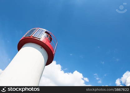 Lighthouse Photovoltaic Sky . Sea Mark at the harbor with blue sky with clouds in background