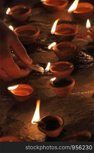 Lighting diyas, traditional oil lamps made from clay, India