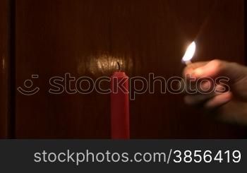 Lighting up a candle with a match.