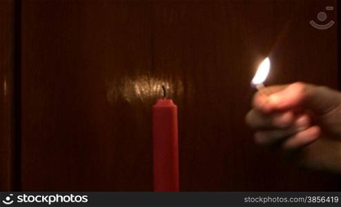 Lighting up a candle with a match.