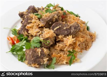 lightly fried lambs liver chunks baked on top of a pilaf of rice, onion, tomato, capsicum and dried currants in a chicken broth, on a small plate garnished with flat-leaf italian parsley. This is an outstanding recipe.
