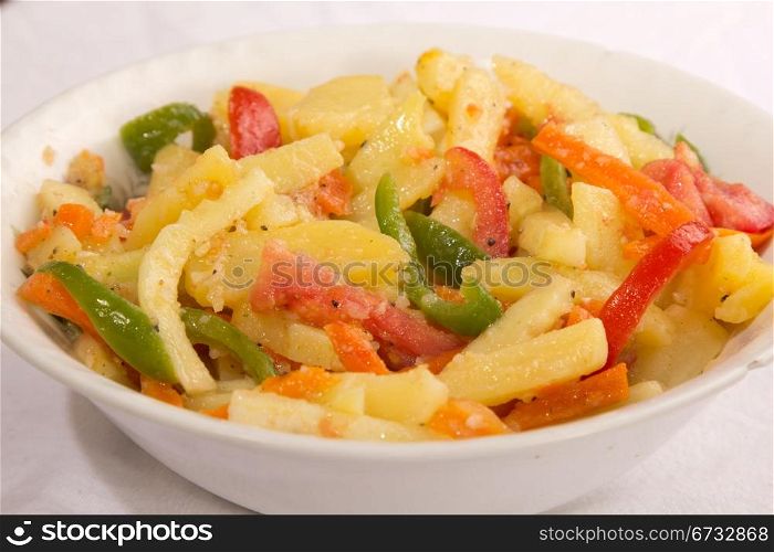 Lightly grilled potato salad with tomatoes, pepper, carrots and potatoes