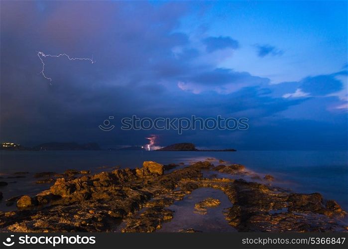 Lightning and storm landscape over beautiful rocky coastline in Mediterranean Sea