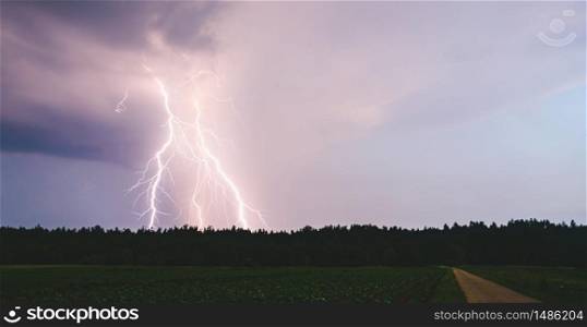 Lightning bolt at night over rural area. Agriculture fields.. Dramatic lightning bolt at night over rural area. Agriculture fields.