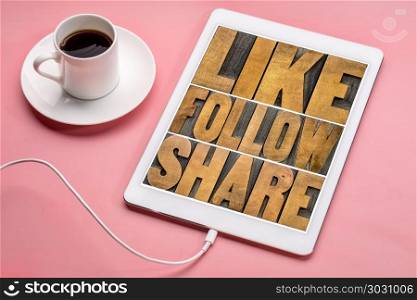 like, follow, share word abstract . like, follow, share social media concept - word abstract in vintage letterpress wood type printing blocks on a digital tbalet with a cup of coffee