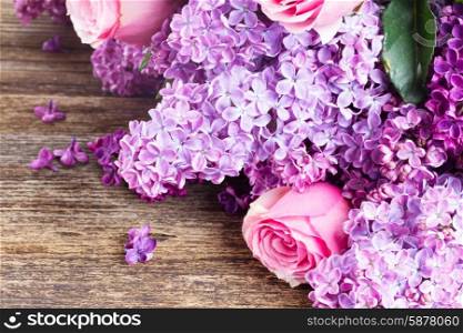 Lilac flowers. Violet Lilac flowers with pink roses close up on wooden table