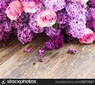 Lilac flowers. Violet Lilac flowers with pink roses on wooden background