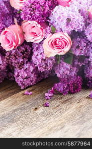 Lilac flowers. Violet Lilac flowers with pink roses on wooden table