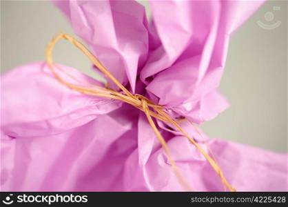 lilac wrapping paper and a bow of bast
