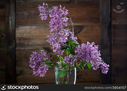 Liliac flowers against wooden background. Lilac flowers against brown wooden background