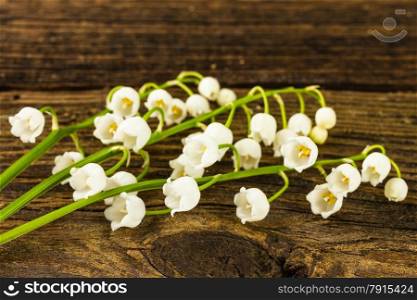 lilies of the valley on wooden background