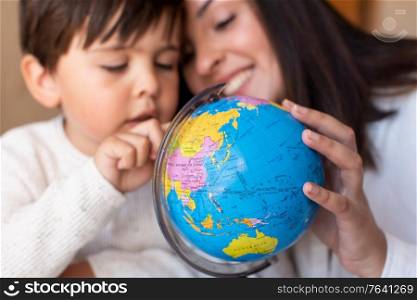 Liltle Preschooler Kid learing geography with a globe map and teacher educador help. Homeshooling. Learning Community. Montessori School