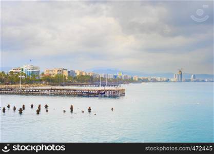 Limassol embankment overcast skyline view with modern apartment buildings, piers and construction site in background, Cyprus