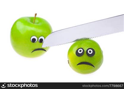 lime and apple with eyes and faces and knife isolated on white
