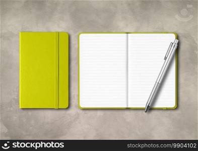Lime green closed and open lined notebooks with a pen . Mockup isolated on concrete background. Lime green closed and open lined notebooks with a pen on concrete background