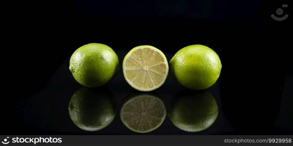Limes on Black Background with Reflection
