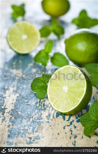 Limes with mint on wooden table background. Macro shot