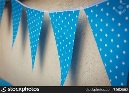 line of colorful blue party decorations flags with white stars illustration hanging from the wall.