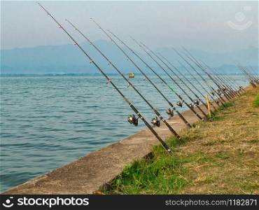 Line of fishing rods at the lake in the morning