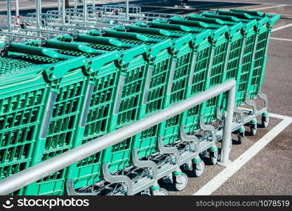 Line of green shopping carts in a supermarket. Outdoor shot