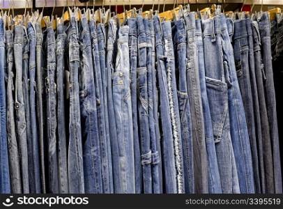 line of many jeans hanging in a shop