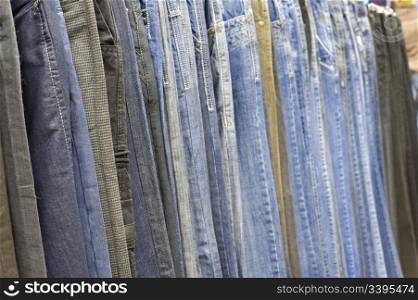 line of many jeans hanging in a shop, shallow DOF