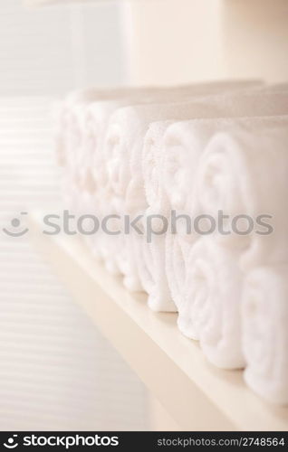 Line of rolled up white bath towels, shallow depth-of-field