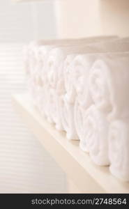 Line of rolled up white bath towels, shallow depth-of-field