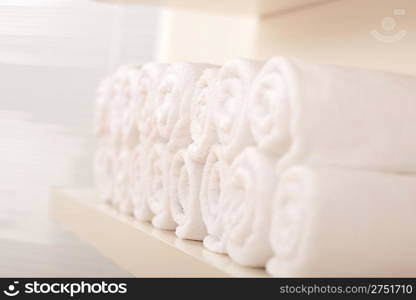 Line of rolled up white bath towels, shallow depth-of-field