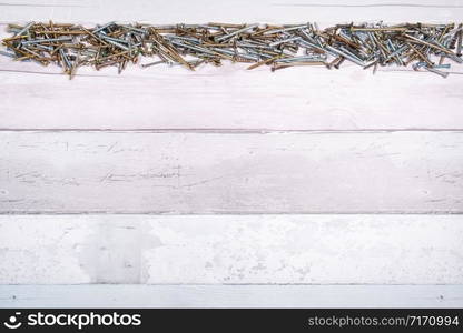 line of screws of different shapes at the top of a free space on wooden background. top view with space for text.. line of screws of different shapes at the top of a free space on wooden background. top view with space for text