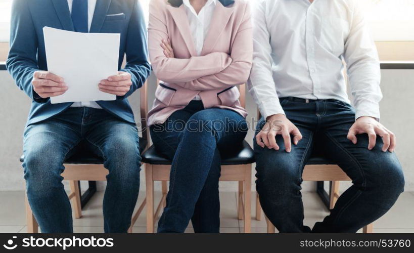 Line of young business people sitting waiting for their turn for interview