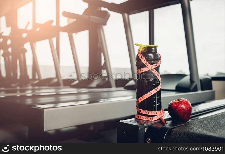 line tape centimeter wrapped around whey bottle at fitness gym
