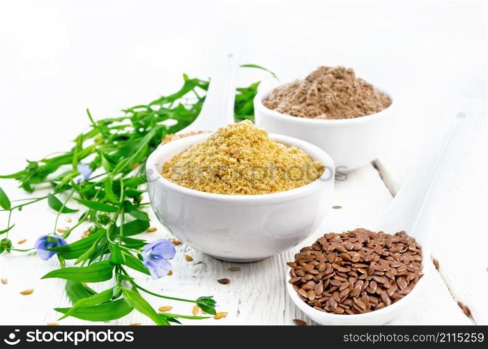 Linen bran and flour in two bowls, seeds in spoons, flax leaves and flowers on the background of a wooden board