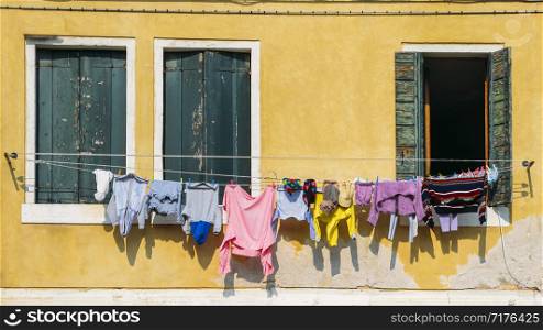 Lines of linen drying on ropes stretched outside colourful window facades in Venice, Italy. Lines of linen drying in Venice, Italy