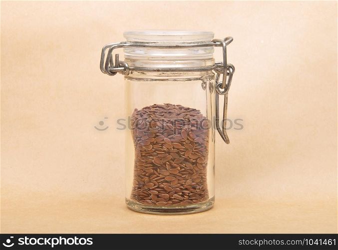 Linseed in glass on brown background